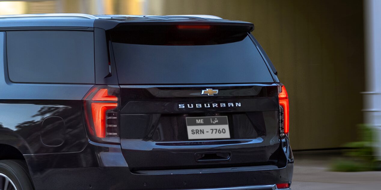 Rear Three-Quarters View of the 2025 Chevrolet Suburban SUV Driving in a City