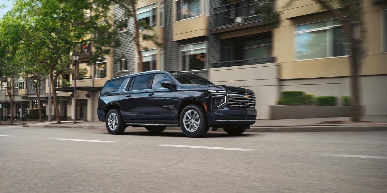Driving image with front three quarters view of 2025 Chevrolet Suburban SUV in city