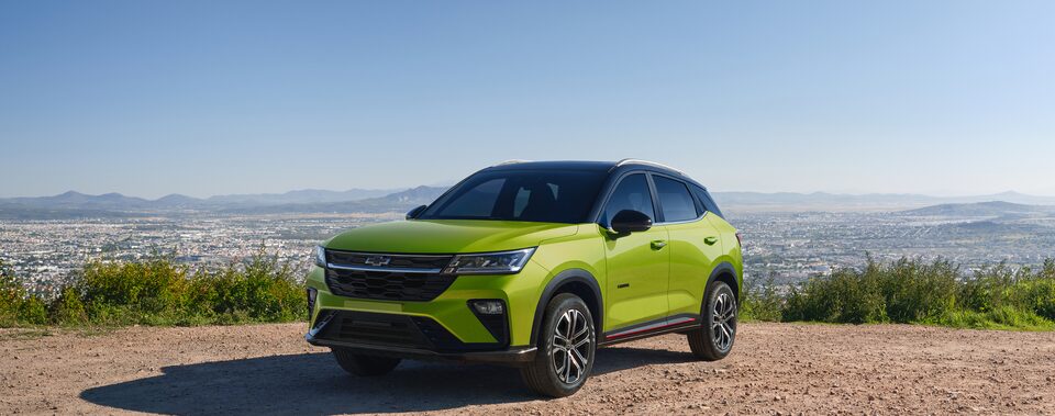 Front Three Quarters of a Green 2026 Chevrolet Groove Parked at a Viewpoint overseeing a Middle-Eastern City Landscape 