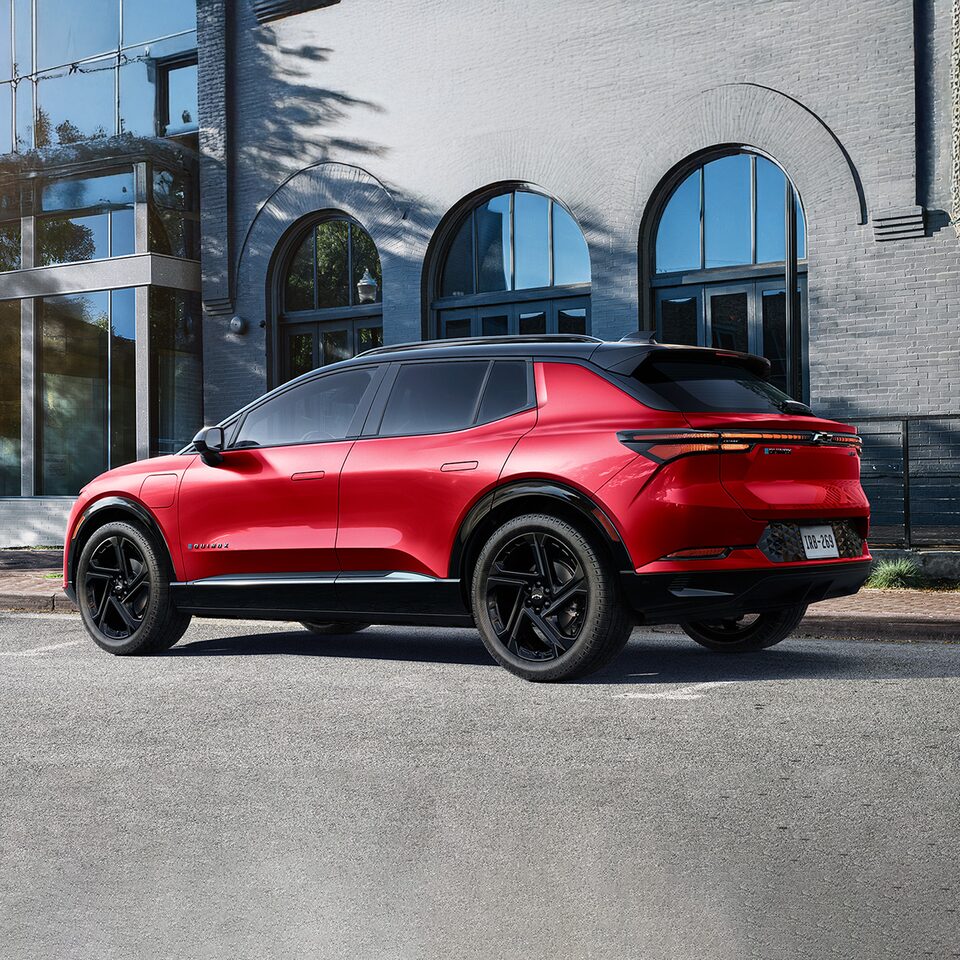 Side View of a Red 2025 Equinox EV Next to a Building