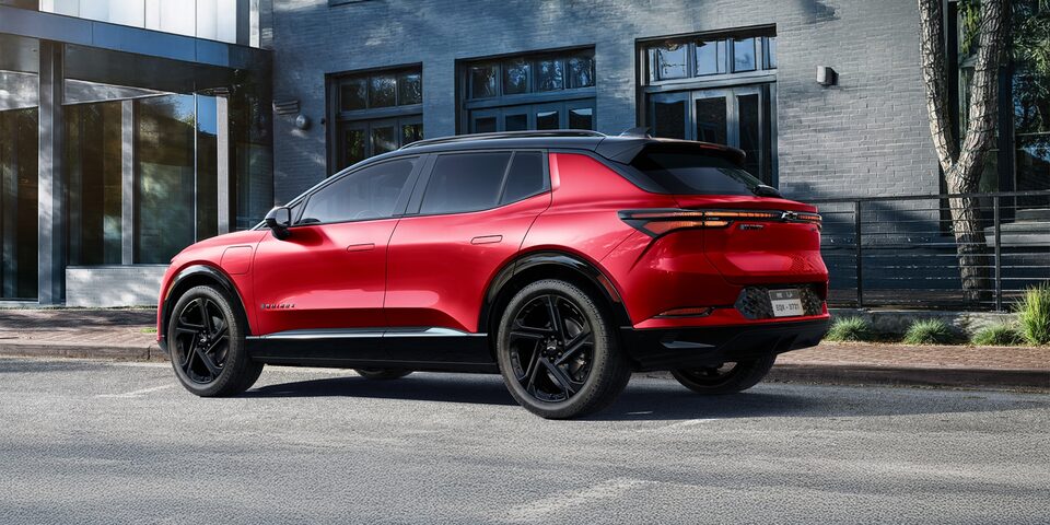 Side View of a Red 2025 Equinox EV Next to a Building