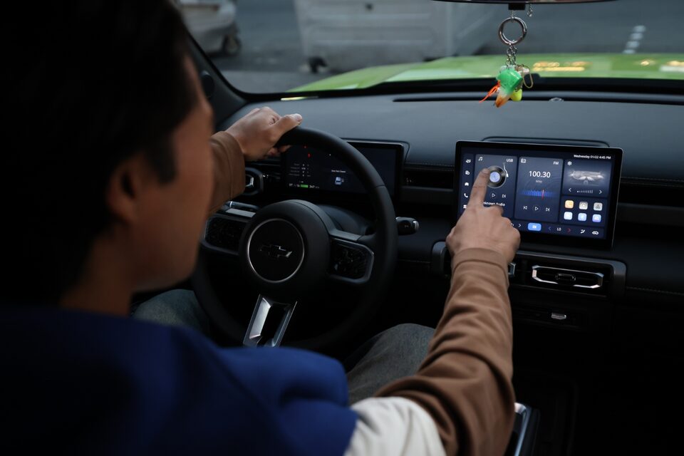 Driver interacting with the Chevrolet Spark EUV’s infotainment touchscreen