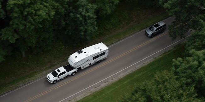 Black Chevy Silverado Towing a Mid-Sized Trailer on an Open Road