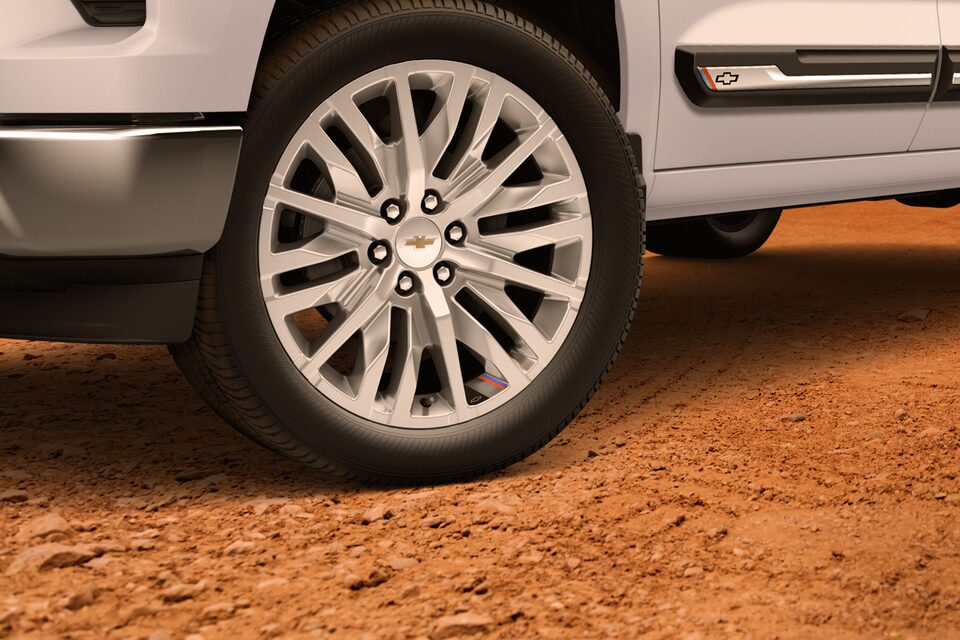 Close-up view of the wheels of the 2025 Chevrolet Silverado Chafar truck on sand in a desert environment.