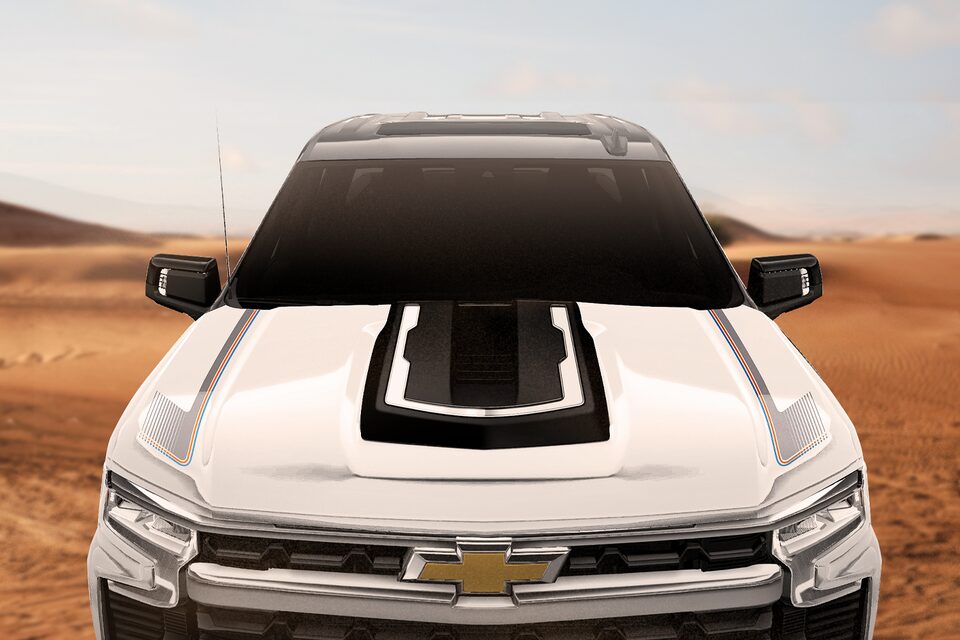 Front view of the hood of the 2025 Silverado Chafar truck, parked on sand in a desert environment.