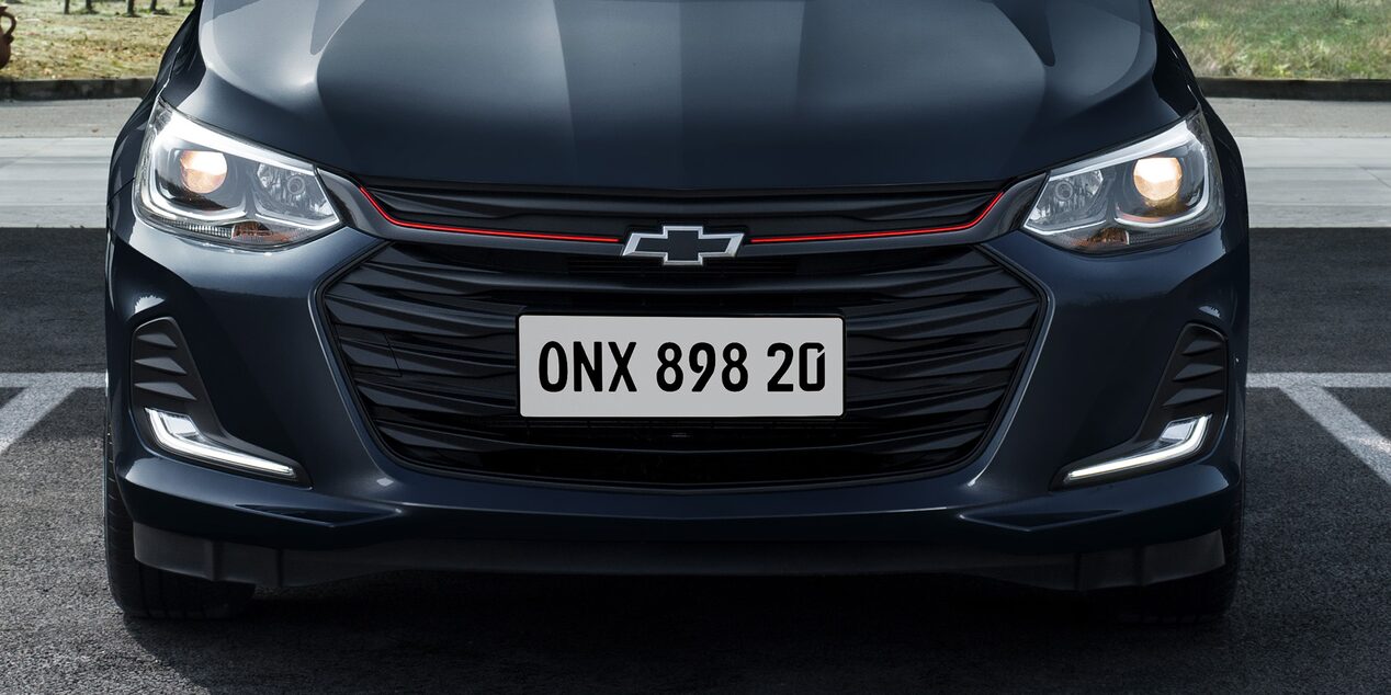 Chevrolet Onix 2026, sedán deportivo con detalles negros y acentos en rojo en parrilla frontal facsia, versión Redline