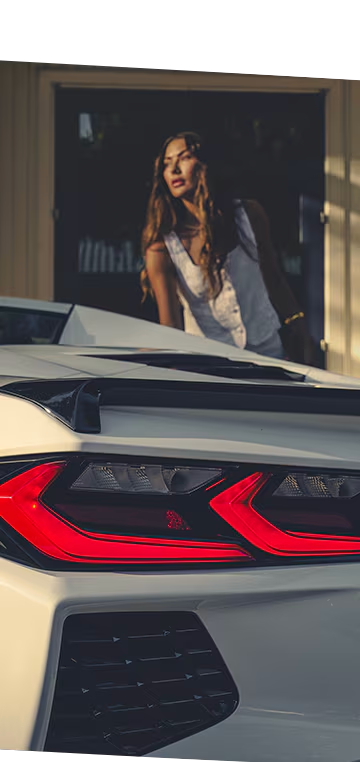 Primer plano del faro trasero del Chevy Corvette Stingray 2026 con una mujer en el fondo