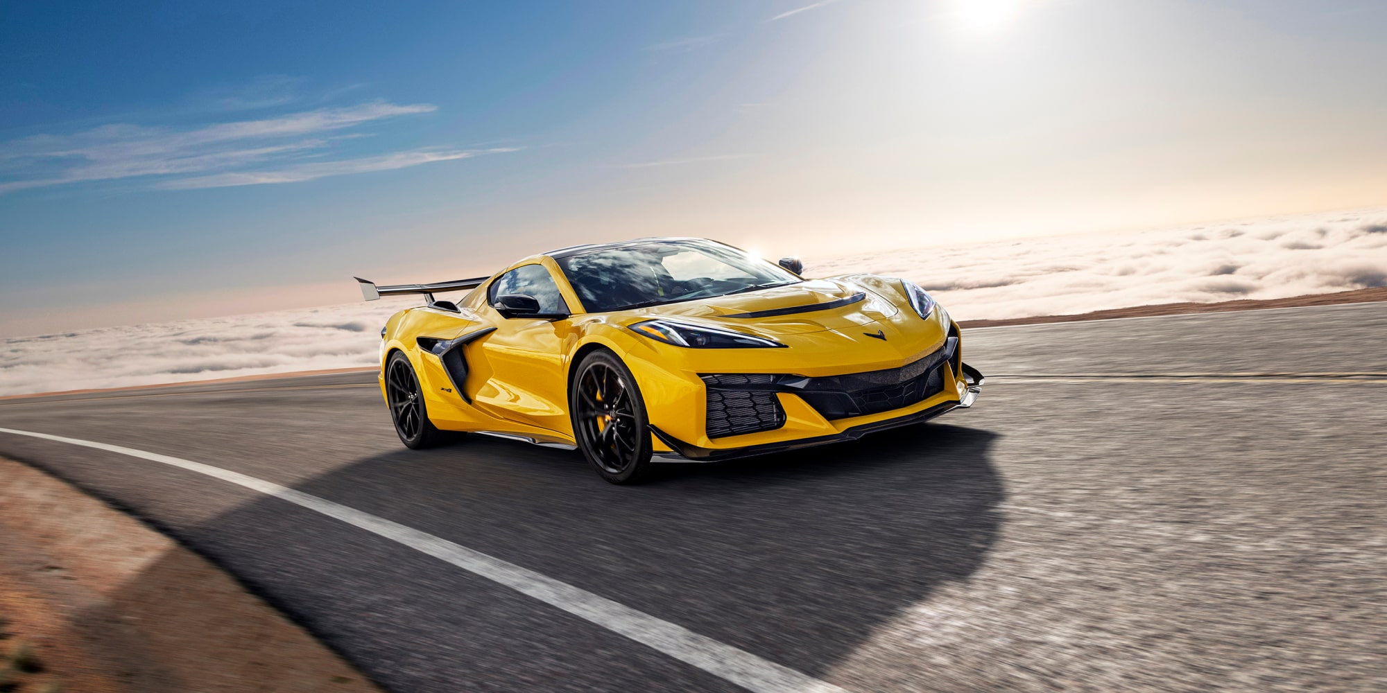 Three Quarter View of a Yellow Chevy Corvette ZR1 Going down a Road on a Sunny Day