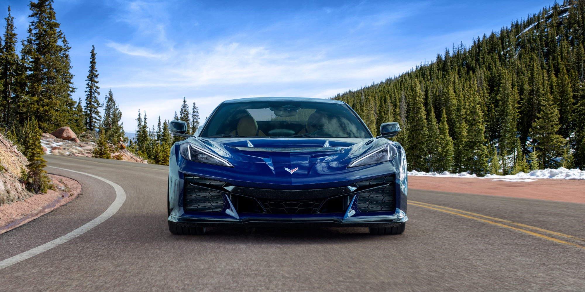 Front View of a Pruple 2026 Chevy Corvette ZR1 Driving Down the Road with a Blue Sky