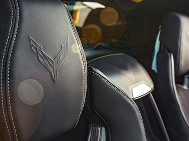 A Close-Up of Black Leather Performance Seats Inside the Chevy Corvette ZR1 Featuring Contrast Stitching, an Embossed Corvette Logo on the Headrest, and the Text “Seats” Displayed in the Corner.