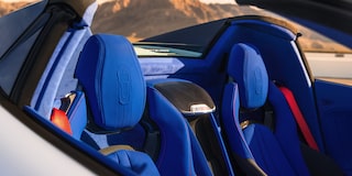 The Blue Leather Seats of a Chevrolet Corvette Grand Sport Convertible Are Shown in Bright Sunlight With Mountains Visible in the Background.