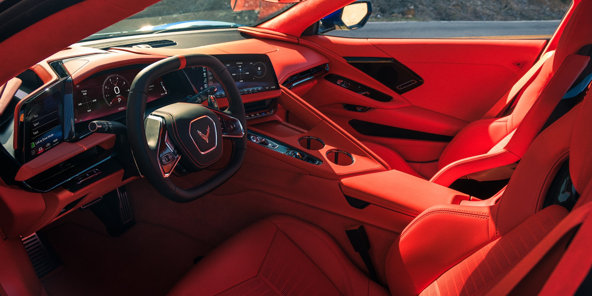 The Red Interior of a Chevrolet Corvette Grand Sport Features a Driver‑Focused Cockpit With a Digital Gauge Cluster, Central Touchscreen, and Dashboard Design.