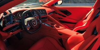 The Red Interior of a Chevrolet Corvette Grand Sport Features a Driver‑Focused Cockpit With a Digital Gauge Cluster, Central Touchscreen, and Dashboard Design.
