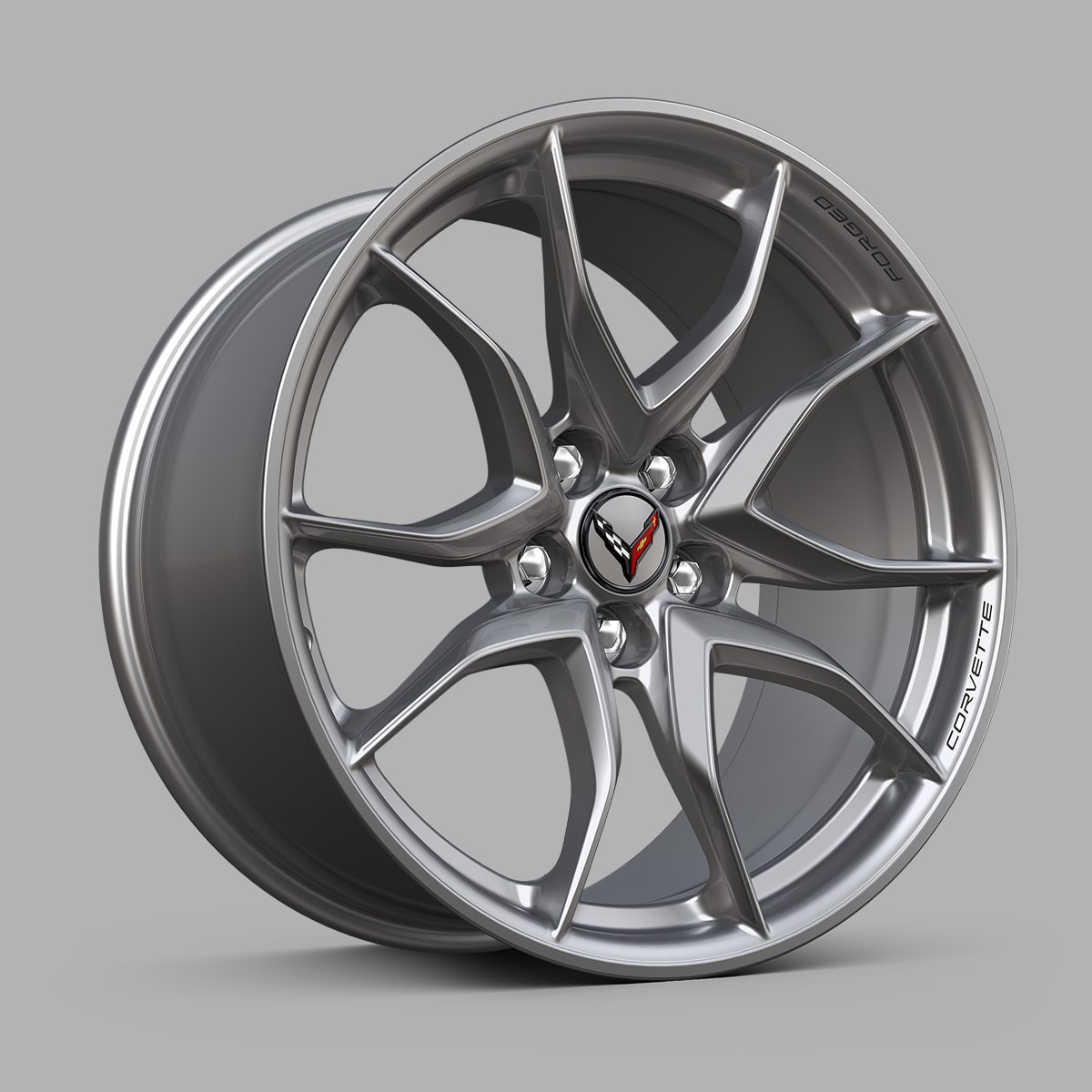 A Silver Chevrolet Corvette Grand Sport Alloy Wheel With a Split‑Five‑Spoke Design Displayed Against a Gray Background.