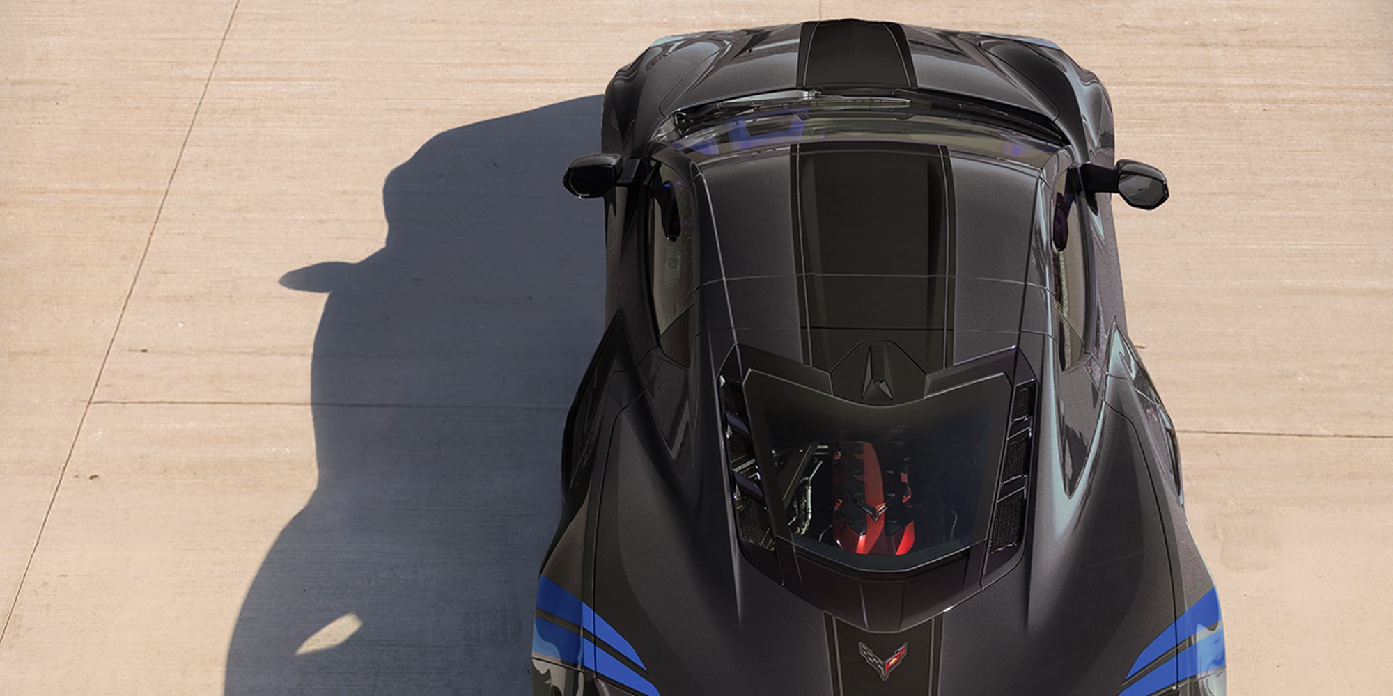 Top View of a Black Corvette Grand Sport with Blue Accent Stripes Blue Chevrolet Corvette Grand Sport with Shadows Cast Across the Ground