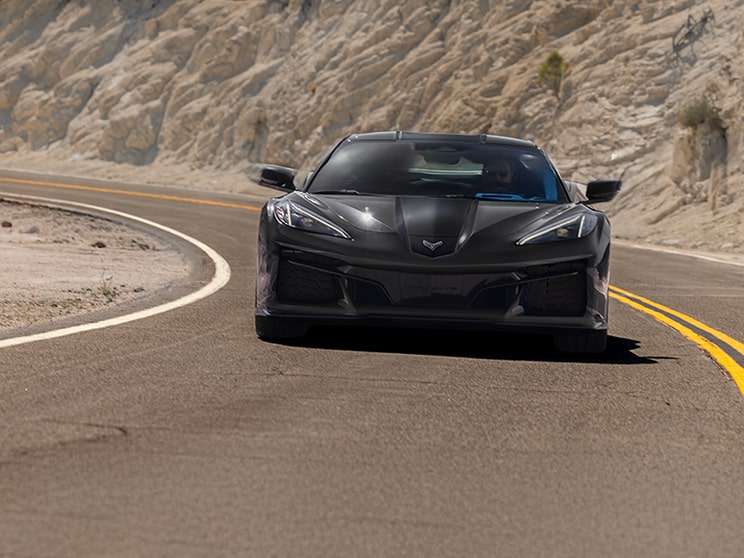 A Close‑Up View of the Digital Instrument and Infotainment Display Inside a Chevrolet Corvette Grand Sport Shows Performance Gauges, Drive Mode Settings, and System Indicators Against Red Interior Trim.