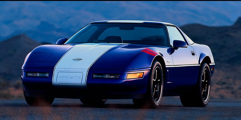 The Red Interior of a Chevrolet Corvette Grand Sport Features a Driver‑Focused Cockpit With a Flat‑Bottom Steering Wheel, Digital Gauge Cluster, and Angular Dashboard Layout.