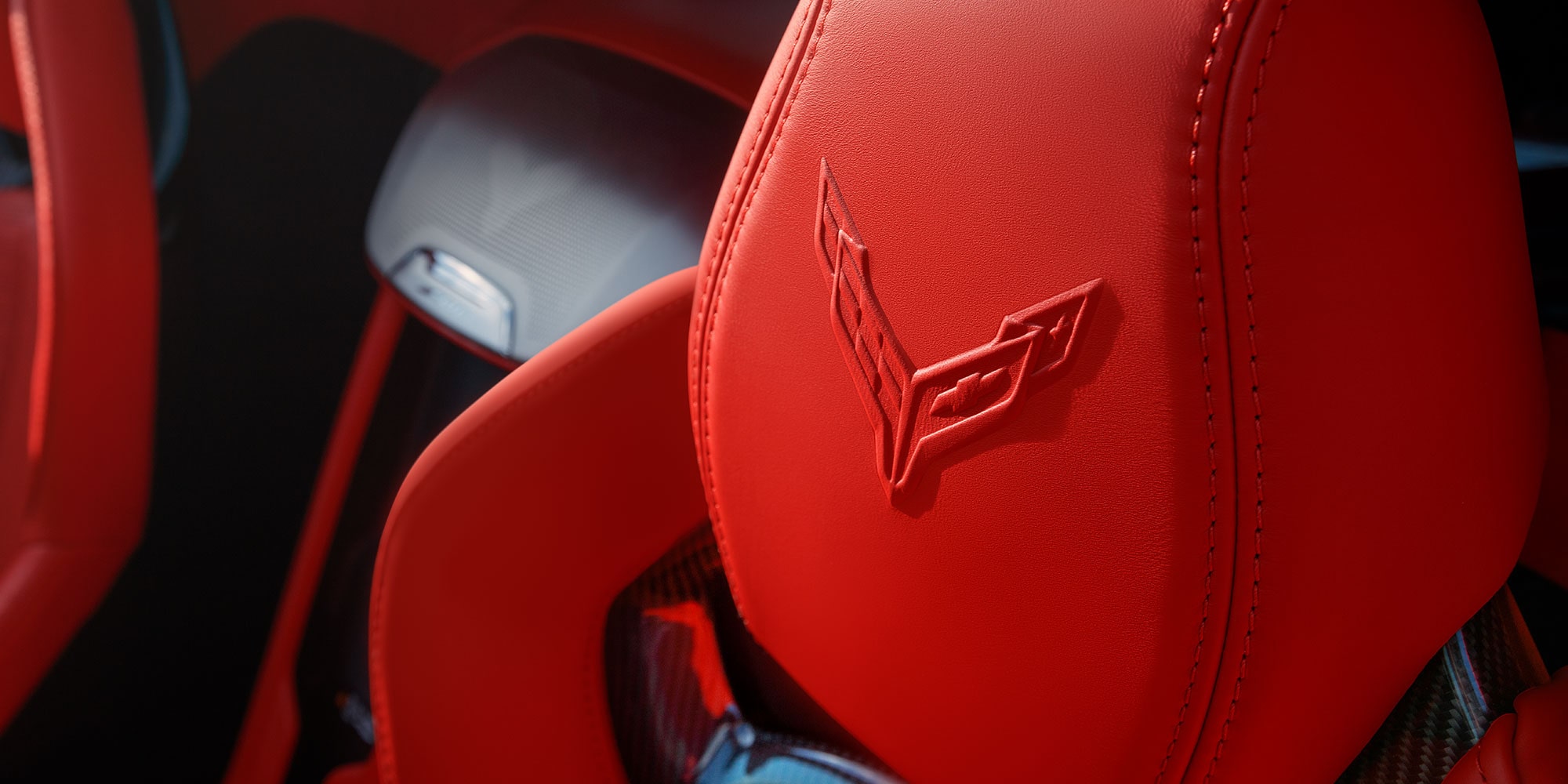 Close-up of the Corvette Logo Imprinted on the Red Leather 2027 Chevy Stingray's Driver Seat Headrest