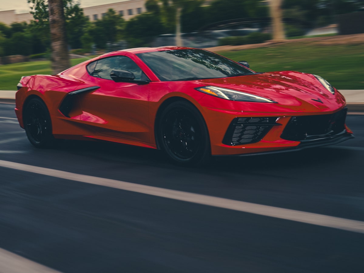 Three-quarter View of a Red 2027 Chevrolet Corvette Stingray Driving Down a Road