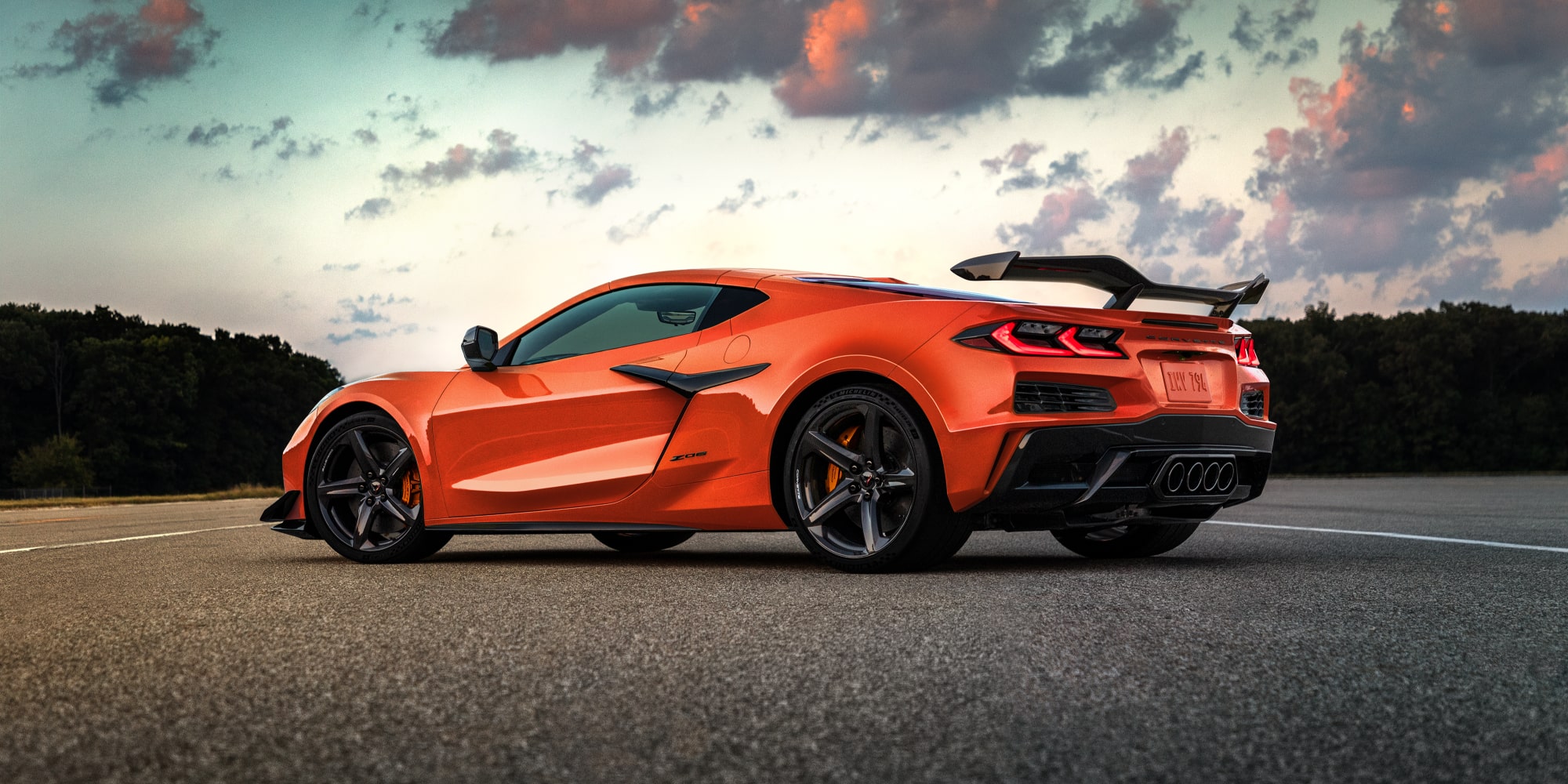 Low Profile View of a Orange 2027 Chevrolet Corvette Z06 Parked on an Open Road Outlooking a Beautiful Sunset
