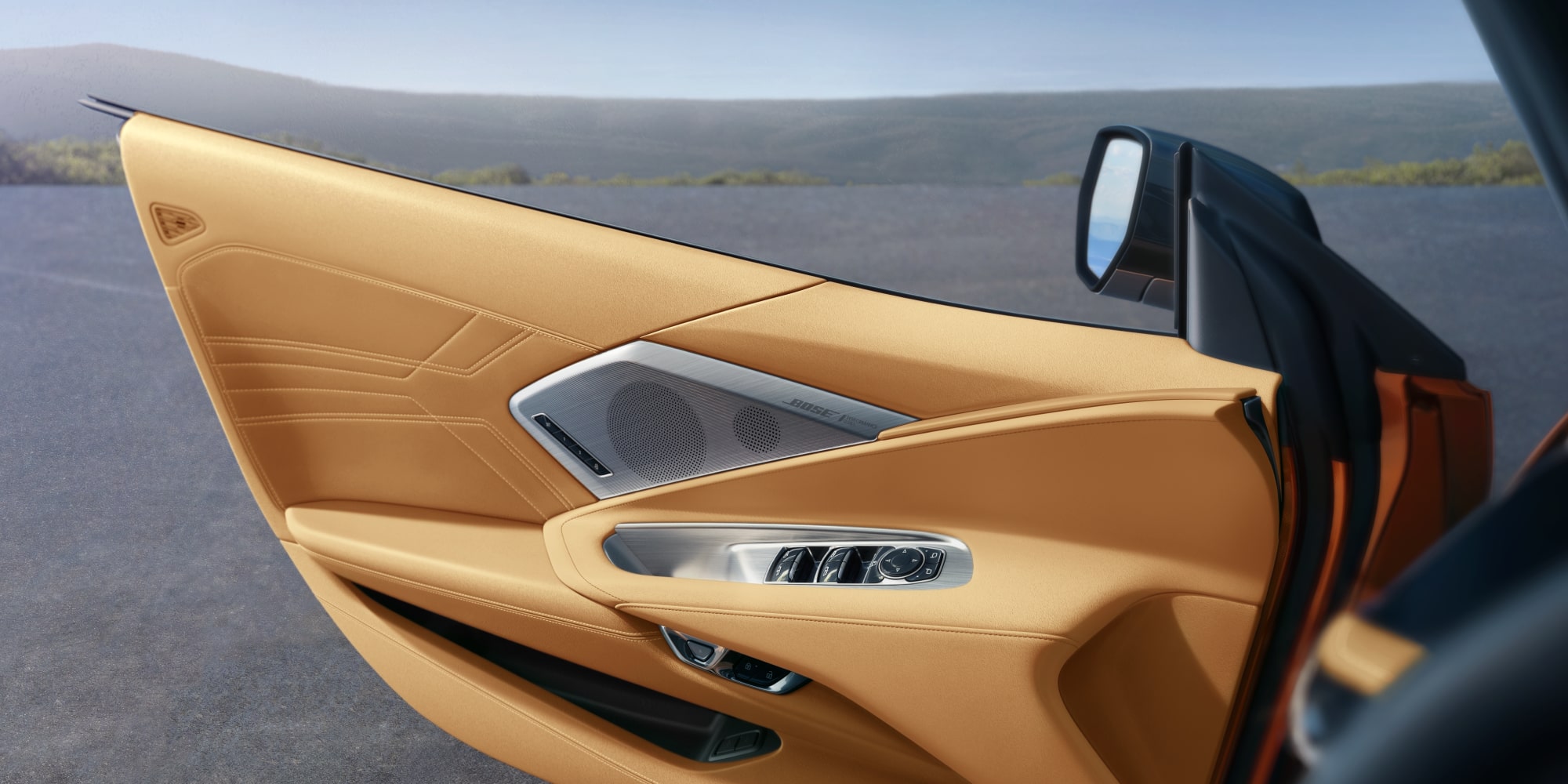 The 2027 Chevrolet Corvette Z06 Driver Door Open Showcasing the Silver Door Controls and a Bose Speaker