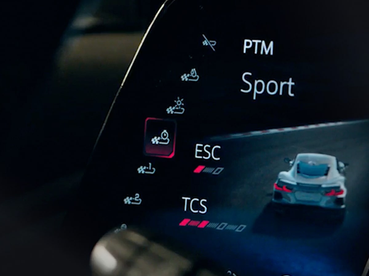 Un primer plano de la pantalla digital dentro de un Chevrolet Corvette Grand Sport donde se observa la configuración del control de tracción de alto desempeño con el modo deportivo resaltado, y los íconos de ESC y TCS.