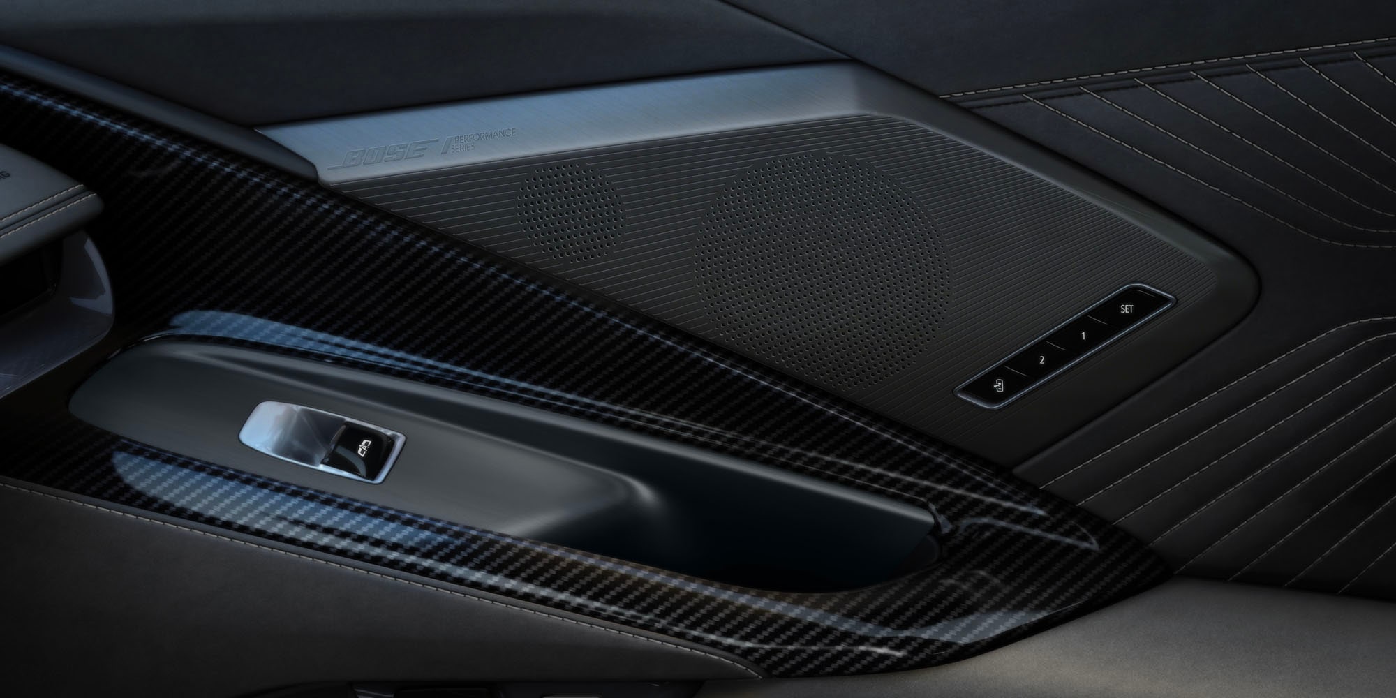 Un primer plano de la consola central de un Chevrolet Corvette Grand Sport donde se observan los controles de interruptores metálicos junto al juego de dos portavasos circulares en un modelo con el interior rojo.
