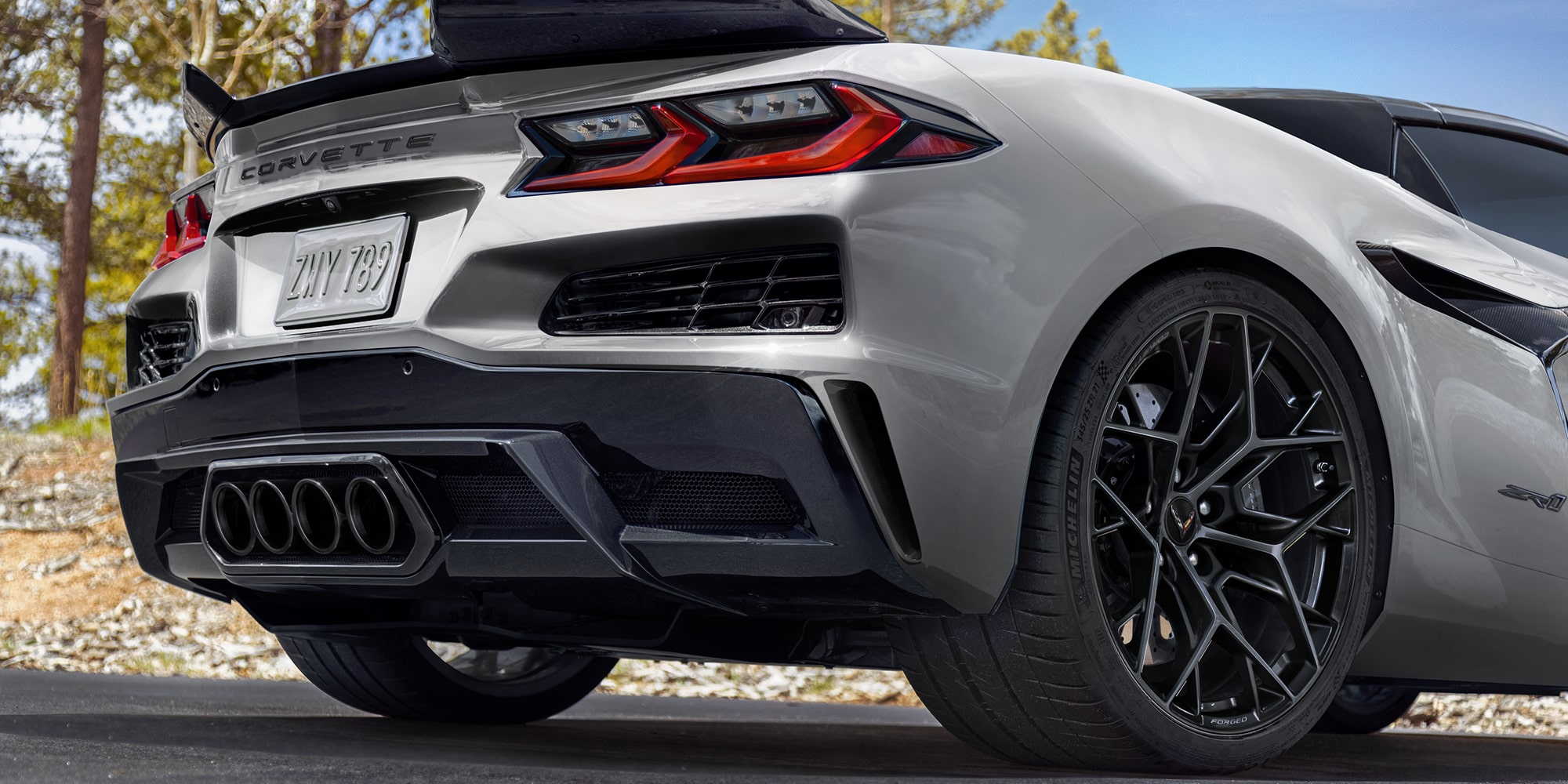 A Close-Up of a Black Multi-Spoke Performance Wheel on a Yellow Chevy Corvette ZR1 Featuring a Large Brake Rotor and Yellow Brake Caliper.