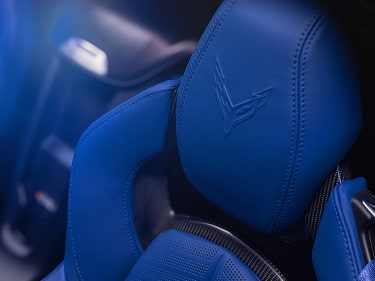 A Close-Up of Blue Leather Performance Seats Inside the Chevy Corvette ZR1X Featuring Perforated Upholstery, Contrast Stitching, and an Embossed Corvette Logo on the Headrest.