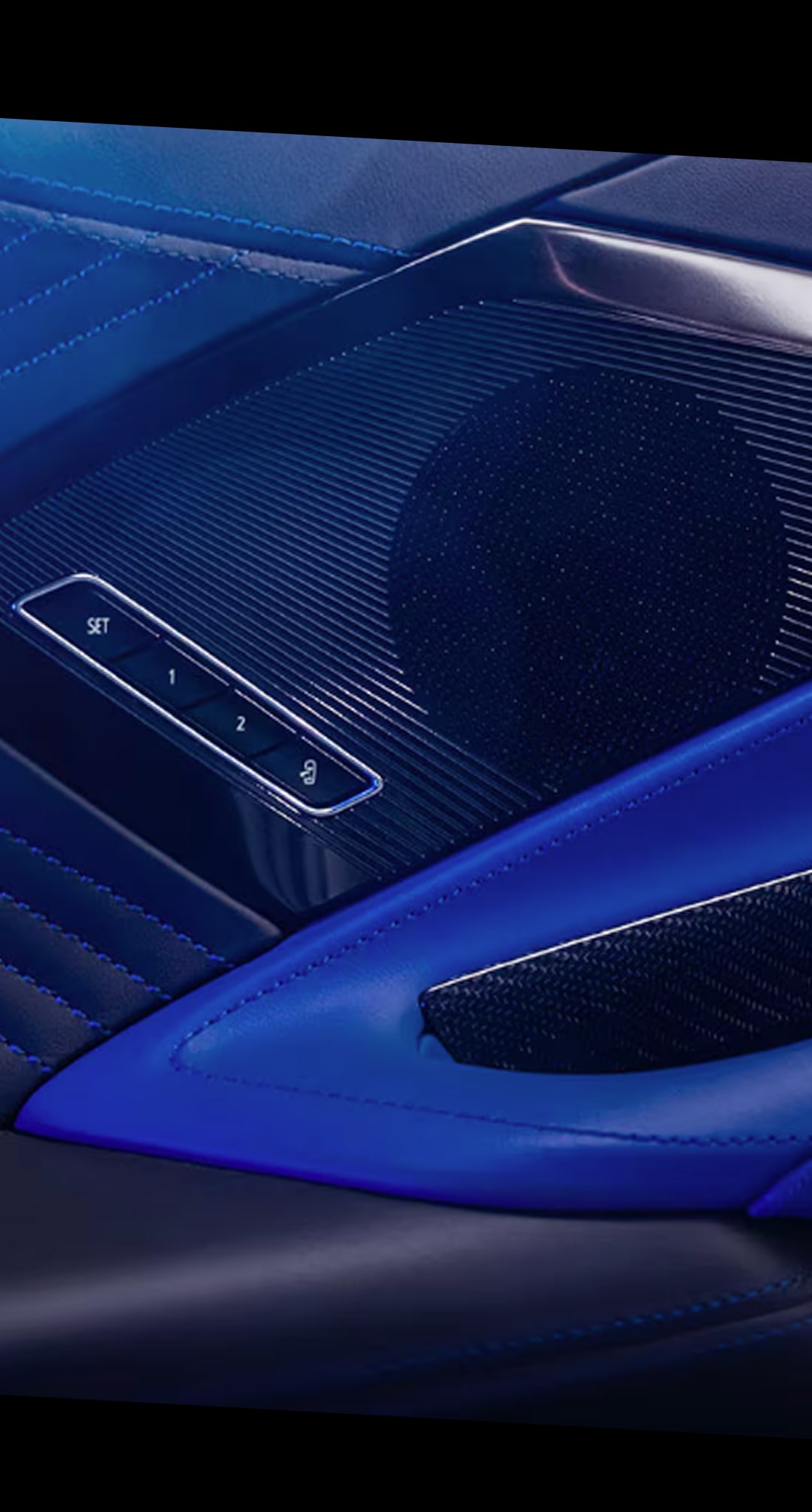 A Close-Up of a Speaker Grille Inside the Chevy Corvette ZR1X Featuring Perforated Metal Integrated into a Blue Leather Door Panel with Subtle Stitching and Soft Lighting.