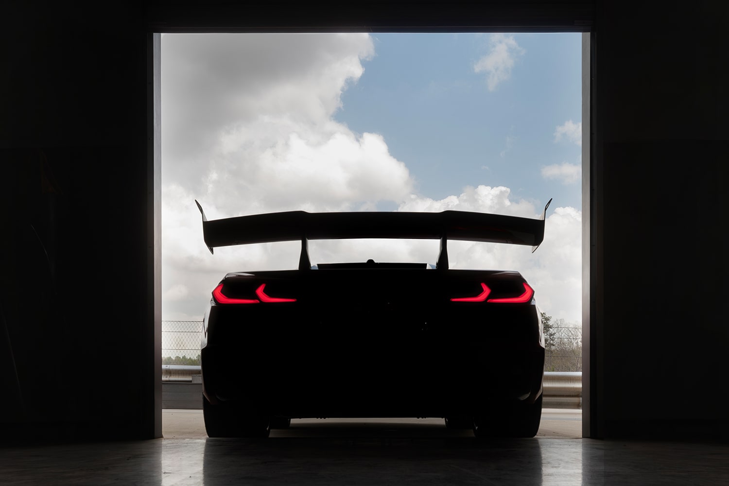 Rear End View of the 2027 Chevy Corvette ZR1X Pulling Out of a Warehouse