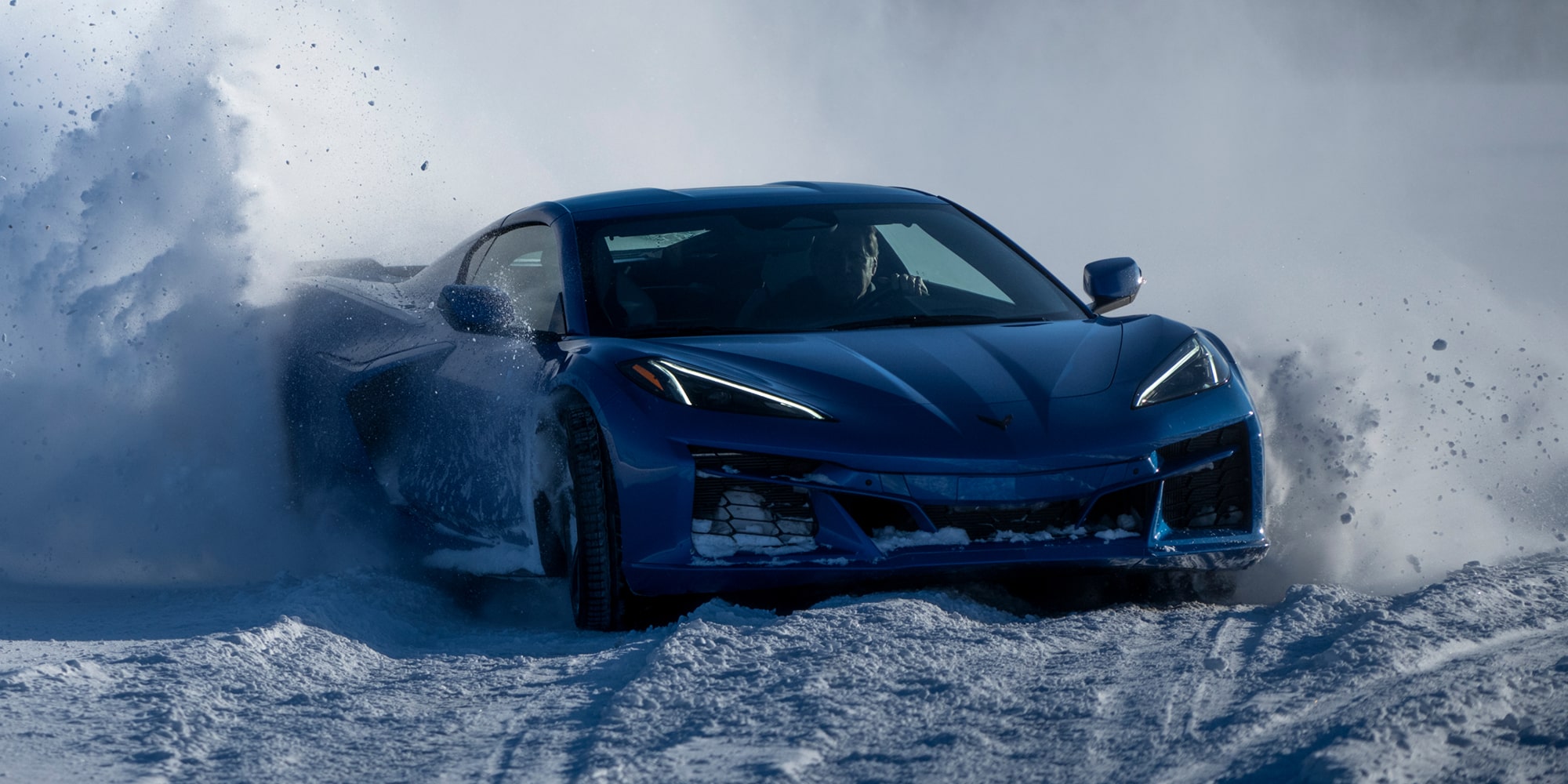 Front View of a Blue Chevy Corvette Stingray Driving Through Snow