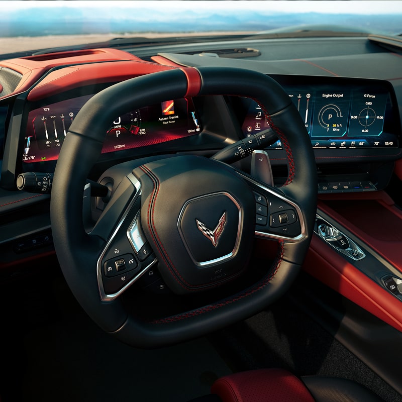 Interior View of a Red and Black Chevy Corvette Stingray Steering Wheel and the Vehicle's Driver Display Info Screens