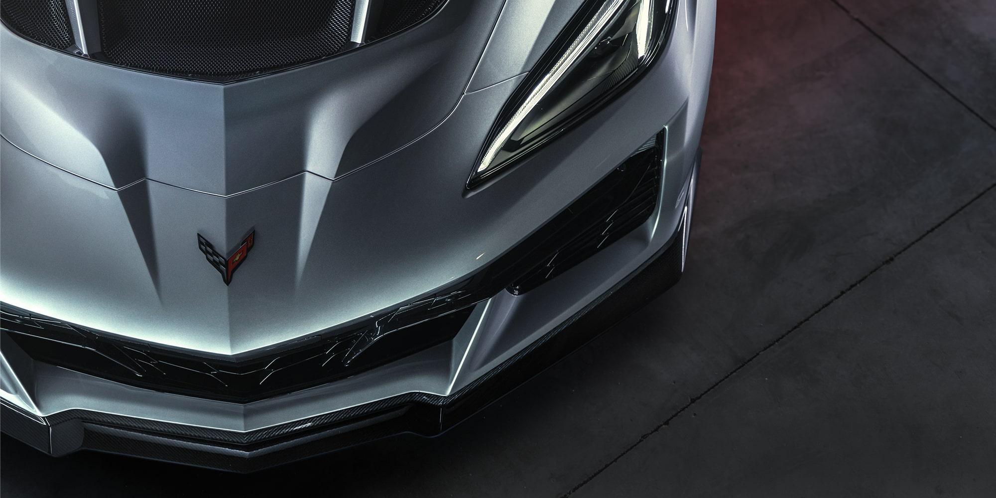 A Top View of the Front Corner and Hood of a Silver Chevrolet Corvette ZR1X Parked On Dark Grey Pavement