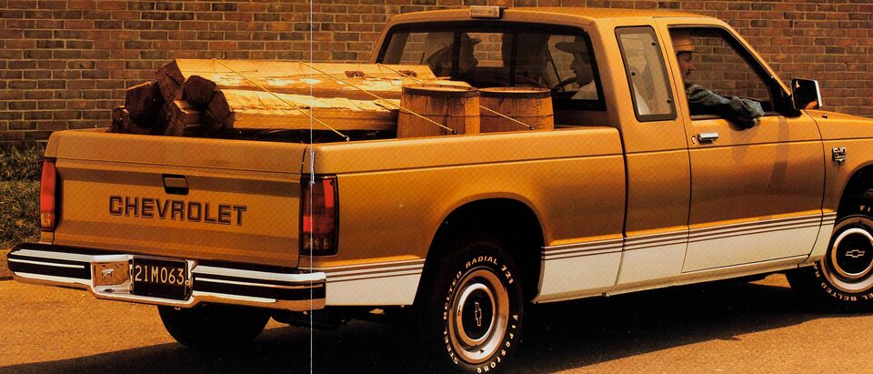 En una foto del folleto de 1983, se ve una pickup Chevy S-10 1983 desde atrás, con su caja llena con una pila de leña y dos barriles.