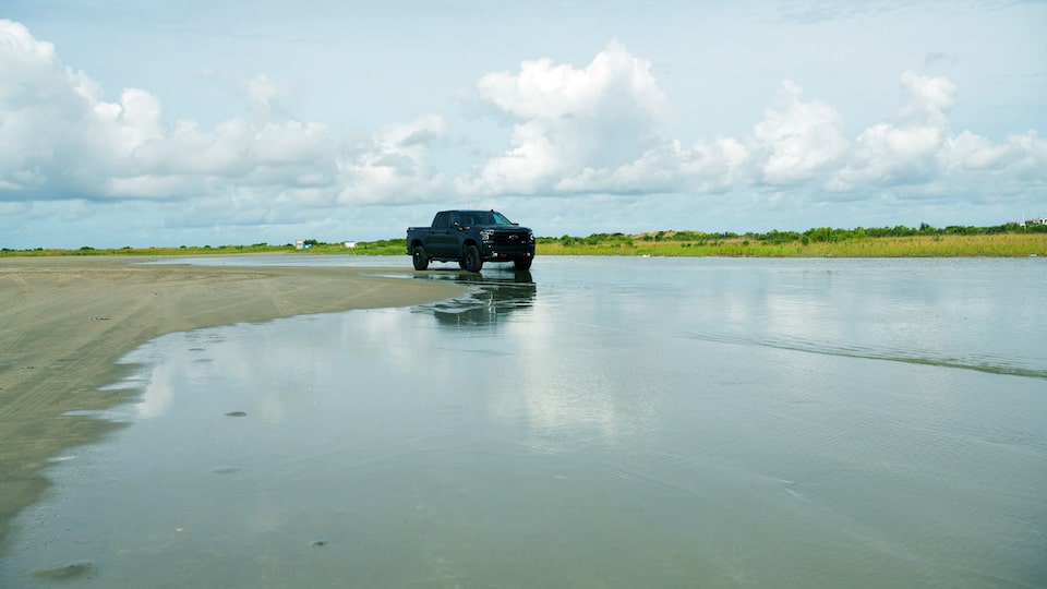 A gray Silverado LT Trail Boss is parked along the edge of a backwater area.