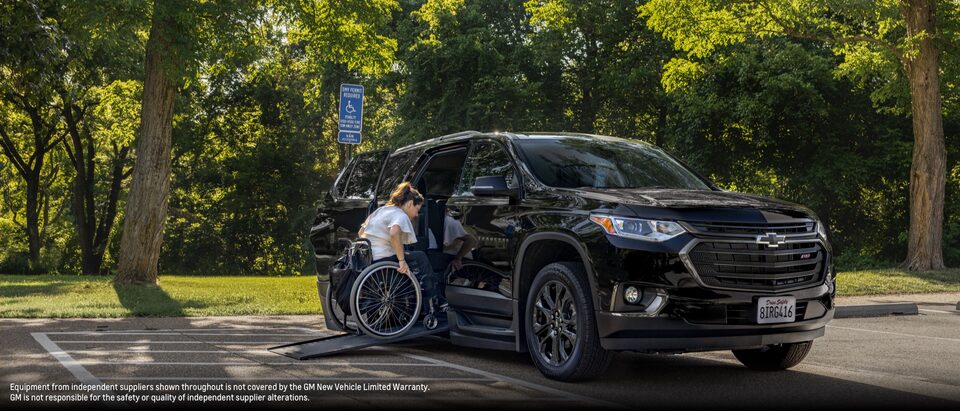 Joanna Bonilla uses a wheelchair to go up a ramp and enter a black Chevy Traverse.