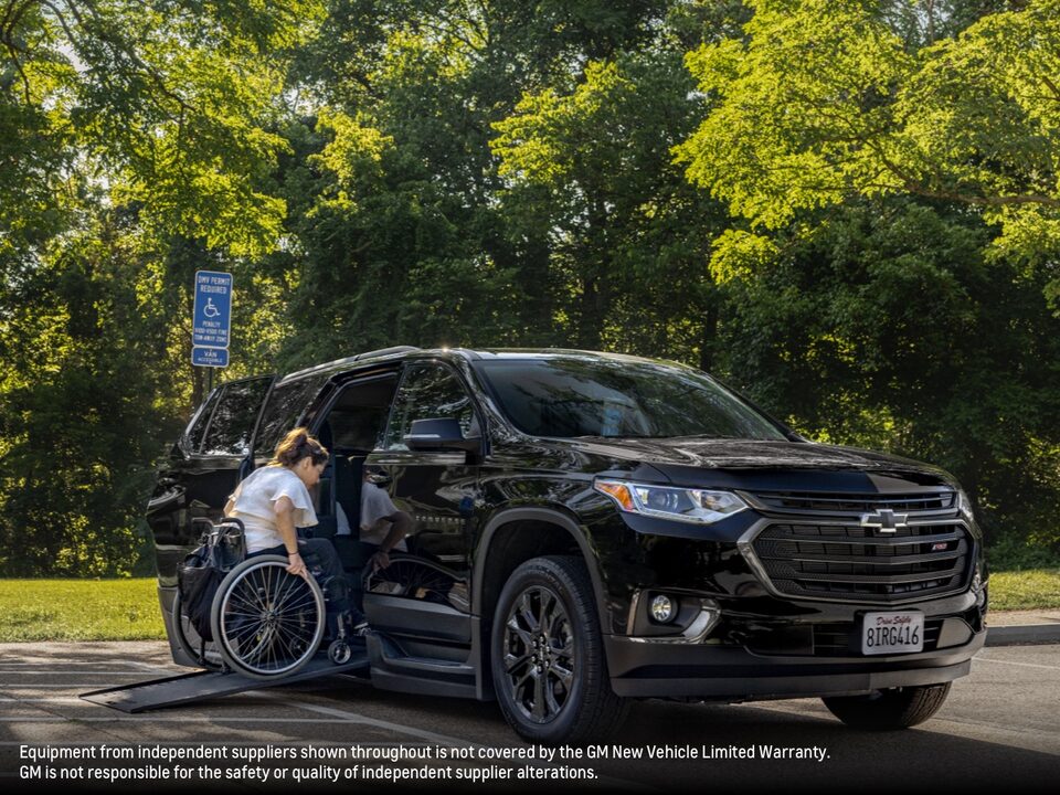 Joanna Bonilla uses a wheelchair to go up a ramp and enter a black Chevy Traverse.