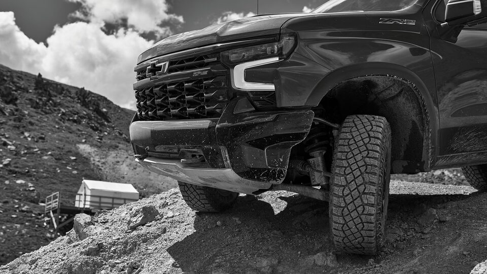 Primer plano de la parte delantera de una Silverado ZR2, mientras comienza a descender por una pendiente rocosa.