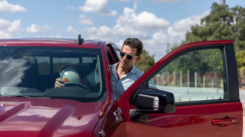 Jon Hagar climbs into the driver’s seat of a red Chevrolet Silverado.