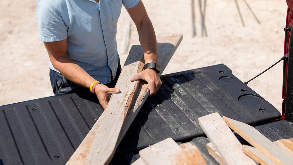 Jon Hagar removes planks of wood from the bed of the Chevrolet Silverado.