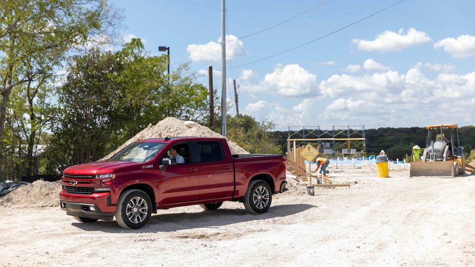 Jon Hagar sits in a red Chevrolet Silverado parked on a construction site.