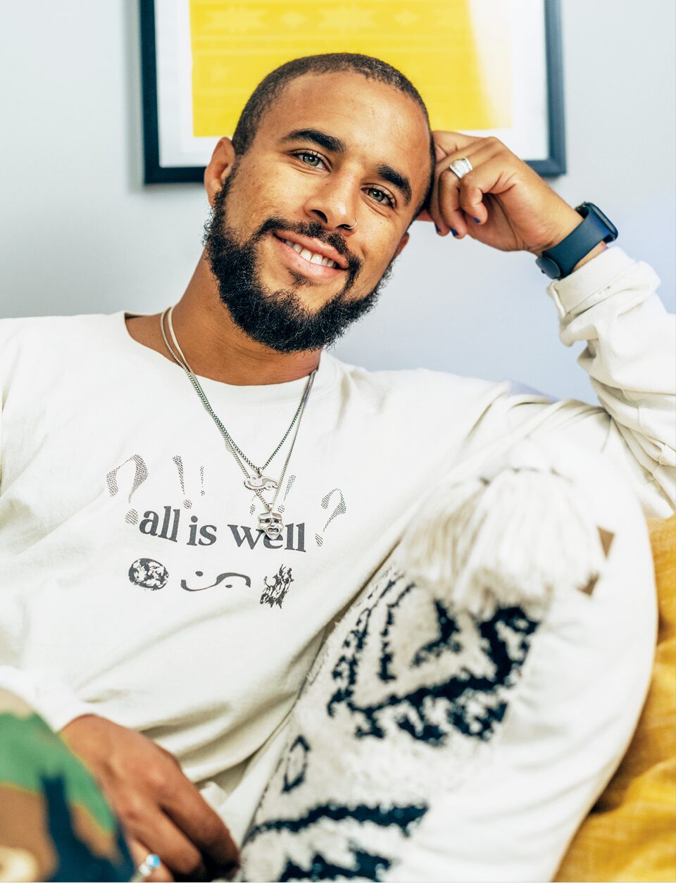 Brad Frey, wearing an "All Is Well" t-shirt, smiles at the camera.