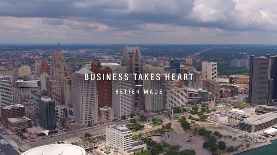 A bird’s-eye view of the Detroit skyline with the text “Business Takes Heart - Better Made” over  the image.