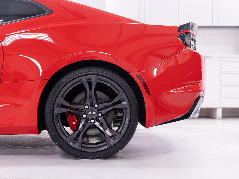El cuarto izquierdo trasero de un Chevy Camaro adentro de la tienda Esoteric Fine Auto Finishing.