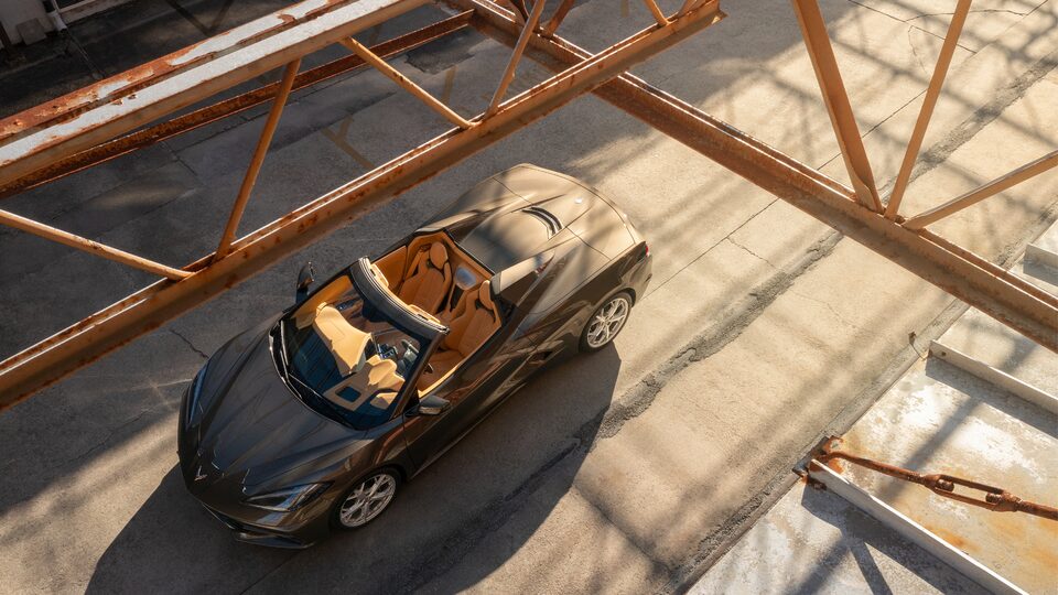 Un Corvette Convertible 2020 en Bronce Zeus Metálico visto desde arriba andando por un camino en el Astillero Naval de Charleston en Carolina del Sur.