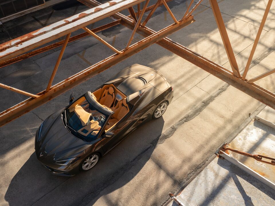 Un Corvette Convertible 2020 en Bronce Zeus Metálico visto desde arriba andando por un camino en el Astillero Naval de Charleston en Carolina del Sur.