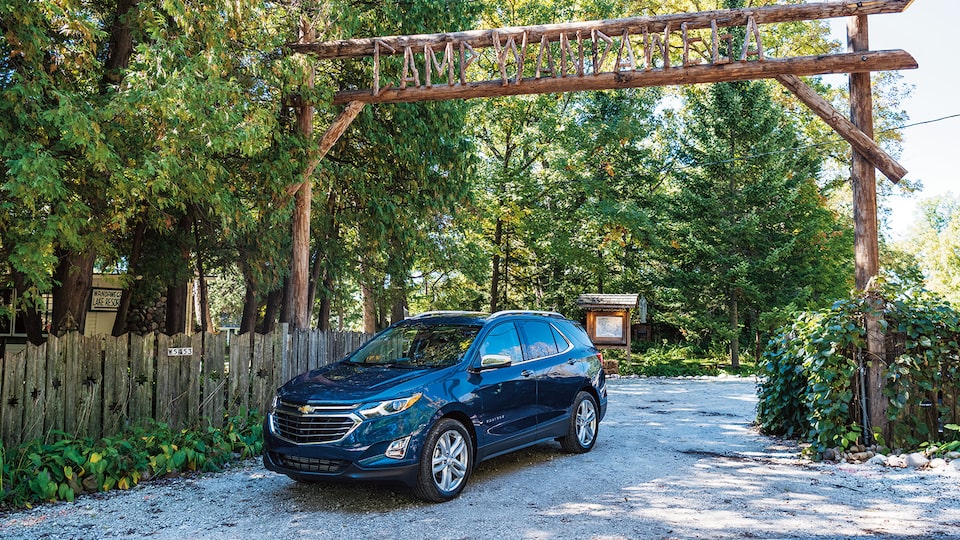 Una Chevrolet Equinox conduce por una entrada de leña rústica y se inscribe en el campamento Wandawega.