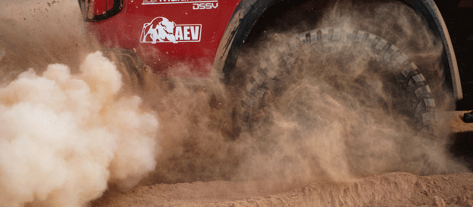 A closeup of one wheel on Chad Hall's racing Colorado ZR2 kicking up dust.