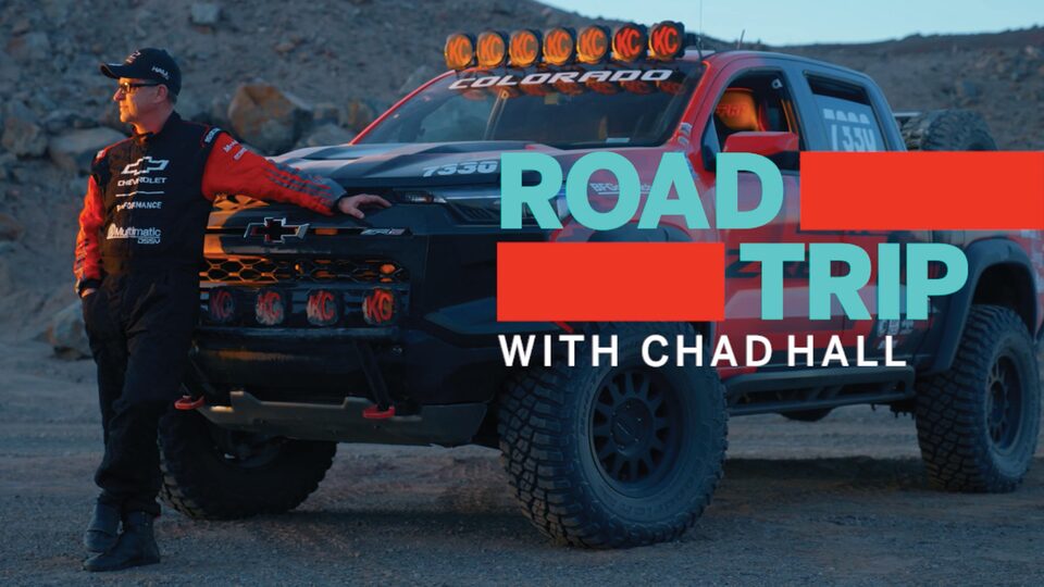 Chad Hall stands in front of his racing Colorado ZR2 in the desert. Words over the image read "Road trip with Chad Hall."